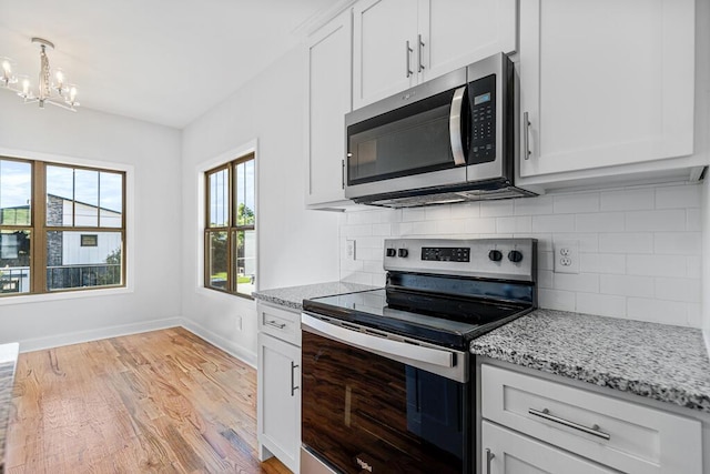 607 Westover Dr SW, Cleveland, TN 37311 - kitchen featuring stainless steel appliances, a chandelier, light wood-type flooring, baseboards, and tasteful backsplash