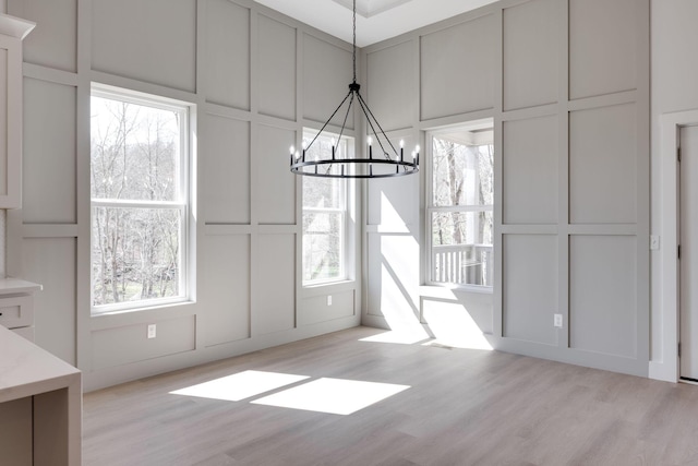 6221 Alexandra Pl, Chattanooga, TN 37416 - unfurnished dining area with a decorative wall, a chandelier, light wood finished floors, and plenty of natural light