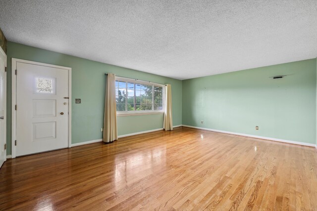 5839 Crestview Dr, Hixson, TN 37343 - unfurnished living room featuring wood finished floors, a textured ceiling, and baseboards
