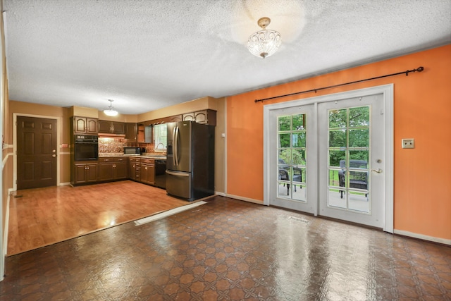 5839 Crestview Dr, Hixson, TN 37343 - kitchen with black appliances, baseboards, a sink, decorative backsplash, and a textured ceiling