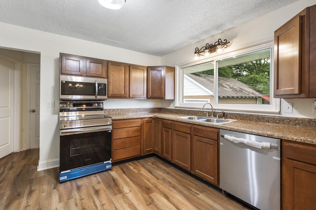 1331 Phils Dr, Chattanooga, TN 37421 - kitchen with appliances with stainless steel finishes, a sink, a textured ceiling, and wood finished floors