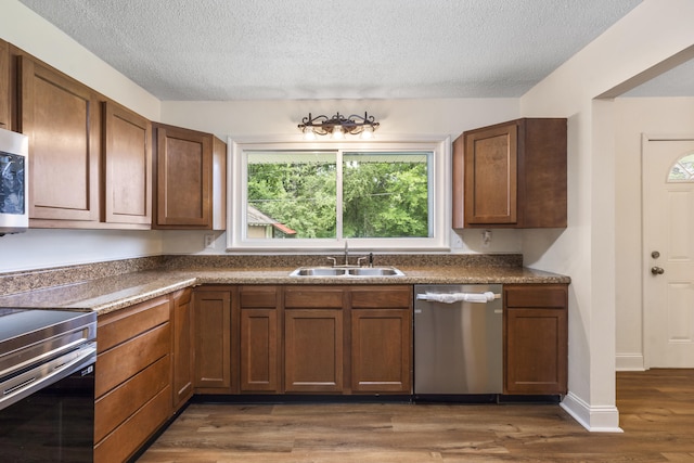 1331 Phils Dr, Chattanooga, TN 37421 - kitchen with stainless steel appliances, a sink, a textured ceiling, dark wood-style floors, and dark countertops