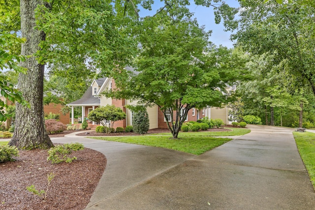 9334 Royal Mountain Dr, Chattanooga, TN 37421 - obstructed view of property with concrete driveway, brick siding, and a front lawn