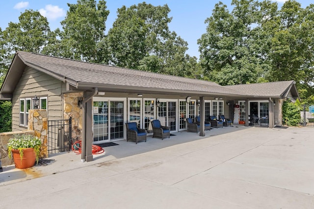 9334 Royal Mountain Dr, Chattanooga, TN 37421 - back of house featuring stone siding, a patio area, roof with shingles, and outdoor lounge area
