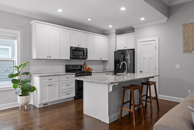 4867 Preserve Dr, Chattanooga, TN 37416 - kitchen with black appliances, ornamental molding, backsplash, white cabinetry, and a center island with sink
