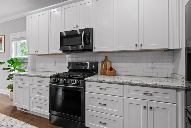4867 Preserve Dr, Chattanooga, TN 37416 - kitchen featuring stainless steel microwave, gas range oven, decorative backsplash, baseboards, and white cabinetry