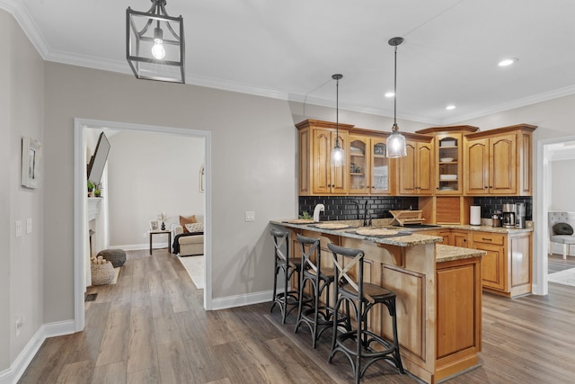 1549 Leighton Dr, Soddy Daisy, TN 37379 - kitchen with brown cabinets, light stone counters, wood finished floors, tasteful backsplash, and a peninsula