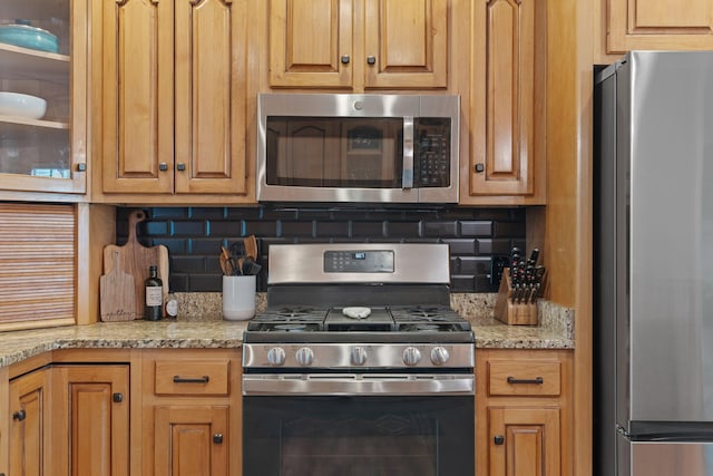1549 Leighton Dr, Soddy Daisy, TN 37379 - kitchen featuring stainless steel appliances, backsplash, glass insert cabinets, and light stone counters