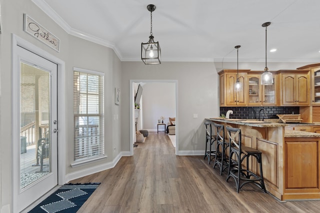 1549 Leighton Dr, Soddy Daisy, TN 37379 - kitchen with glass insert cabinets, a breakfast bar, wood finished floors, light stone counters, and decorative backsplash
