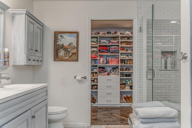 201 N Tibbs Rd, Dalton, GA 30720 - full bath with vanity, a shower stall, toilet, wood finished floors, and a walk in closet