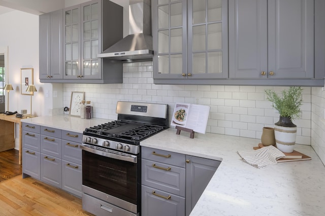 1501 Chamberlain Ave, Chattanooga, TN 37404 - kitchen with gas stove, wall chimney range hood, gray cabinetry, and glass insert cabinets