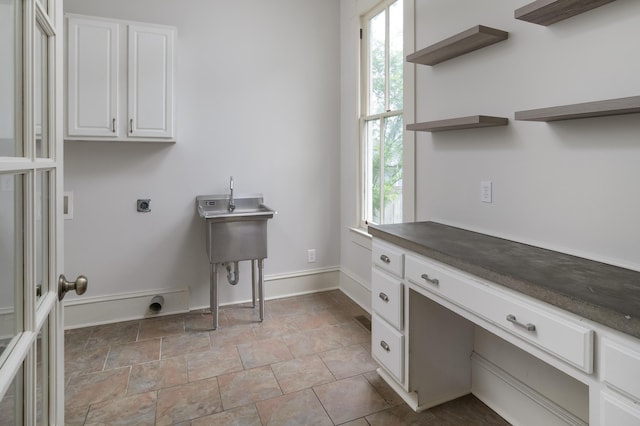 1501 Chamberlain Ave, Chattanooga, TN 37404 - laundry area featuring hookup for an electric dryer, cabinet space, a desk, light stone finish floors, and baseboards