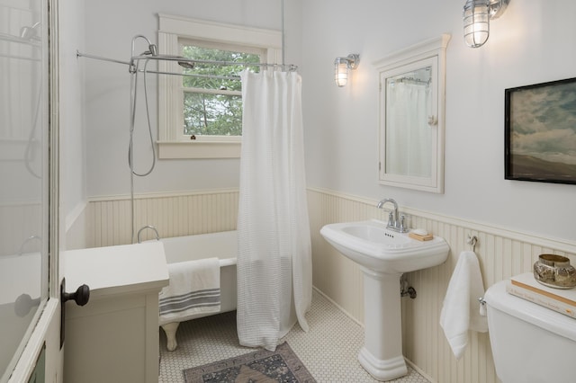 1501 Chamberlain Ave, Chattanooga, TN 37404 - full bathroom featuring toilet, a wainscoted wall, and shower / bath combo with shower curtain