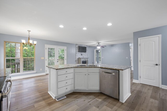 1804 Staghorn Dr, Soddy Daisy, TN 37379 - kitchen featuring stainless steel dishwasher, a sink, light wood-type flooring, ceiling fan, and white cabinetry