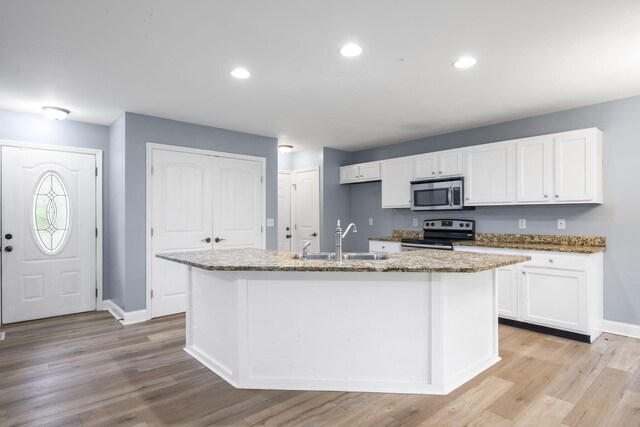 1804 Staghorn Dr, Soddy Daisy, TN 37379 - kitchen featuring stainless steel appliances, a sink, white cabinets, light stone counters, and a center island with sink
