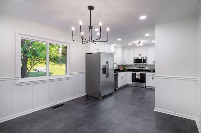 1306 Phyllis Ln, Chattanooga, TN 37421 - kitchen with appliances with stainless steel finishes, a decorative wall, a chandelier, dark countertops, and white cabinets