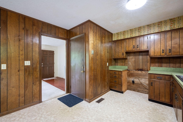 6515 Grubb Rd, Hixson, TN 37343 - kitchen with wooden walls, light countertops, brown cabinetry, and a textured ceiling