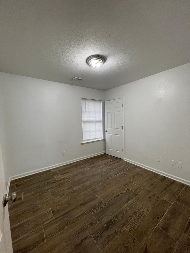 2107 Stuart St, Chattanooga, TN 37406 - spare room featuring dark wood finished floors, a textured ceiling, and baseboards