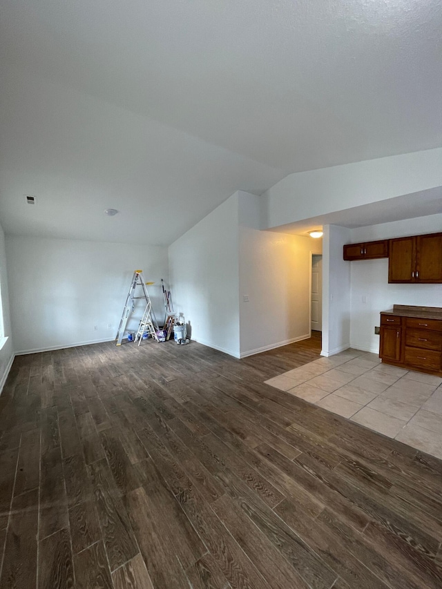 2107 Stuart St, Chattanooga, TN 37406 - unfurnished living room featuring wood finished floors, baseboards, and vaulted ceiling