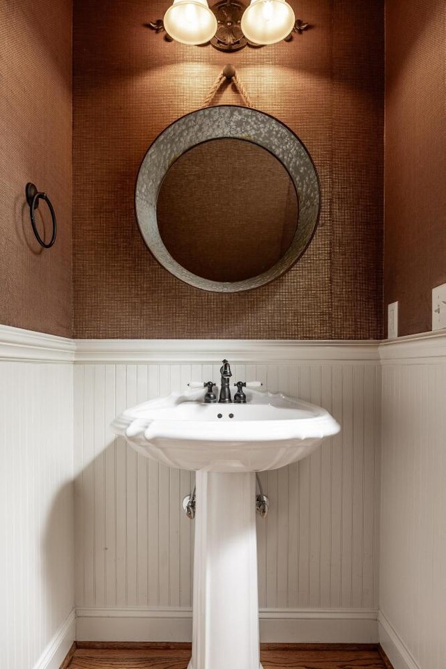 8650 Homecoming Dr, Chattanooga, TN 37421 - bathroom with wood finished floors, a wainscoted wall, a sink, and baseboards
