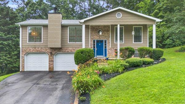 270 Rolling Meadows Dr, Ringgold, GA 30736 - raised ranch featuring an attached garage, asphalt driveway, a front lawn, a chimney, and brick siding