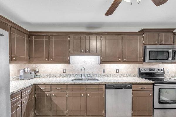 270 Rolling Meadows Dr, Ringgold, GA 30736 - kitchen featuring appliances with stainless steel finishes, a sink, ceiling fan, decorative backsplash, and light stone countertops