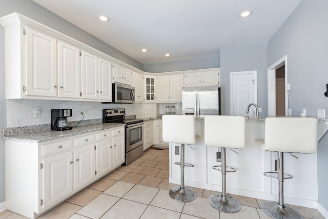 8021 Hamilton Mill Dr, Chattanooga, TN 37421 - kitchen featuring stainless steel appliances, a breakfast bar area, white cabinets, and recessed lighting