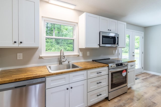 8539 Ricardo Ln, Hixson, TN 37343 - kitchen with stainless steel appliances, wooden counters, a sink, white cabinets, and light wood-type flooring