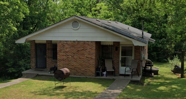bungalow featuring brick siding and a front lawn