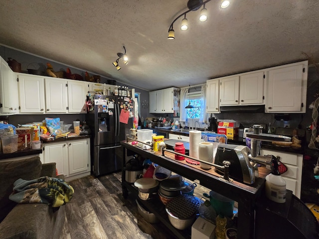 1577 Benton Station Rd, Benton, TN 37307 - kitchen with stainless steel fridge, dark wood-style flooring, a textured ceiling, white cabinetry, and lofted ceiling