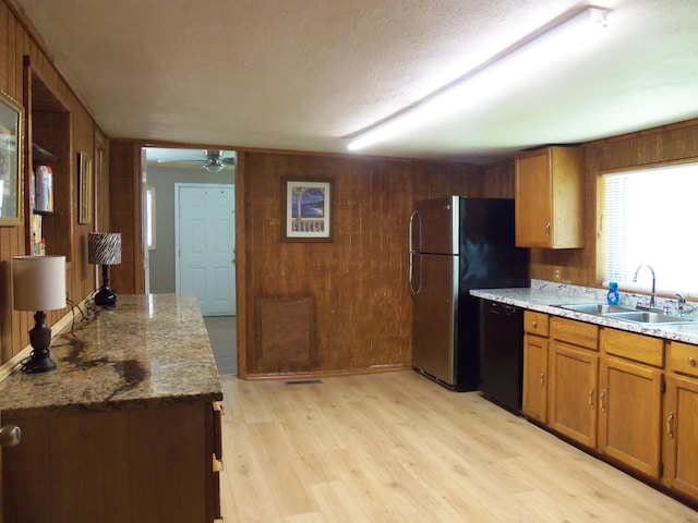 895 W Schmitt Rd, Rossville, GA 30741 - kitchen with black dishwasher, a sink, wooden walls, freestanding refrigerator, and brown cabinetry