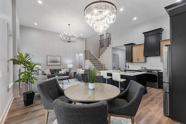 300 Dogwood Ln, Fort Oglethorpe, GA 30742 - dining room with a chandelier, stairway, light wood-style flooring, recessed lighting, and a towering ceiling