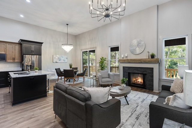 300 Dogwood Ln, Fort Oglethorpe, GA 30742 - living area with a chandelier, a high ceiling, light wood-style floors, healthy amount of natural light, and a fireplace