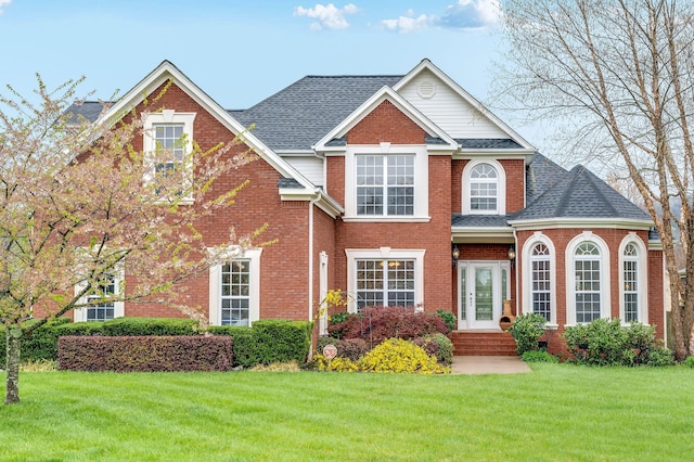 7532 Tranquility Dr, Ooltewah, TN 37363 - traditional-style home with a front yard, brick siding, and a shingled roof