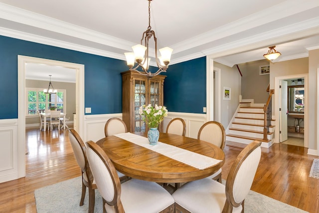 3429 Willow Lake Cir, Chattanooga, TN 37419 - dining space with a chandelier, stairs, crown molding, light wood-style floors, and wainscoting