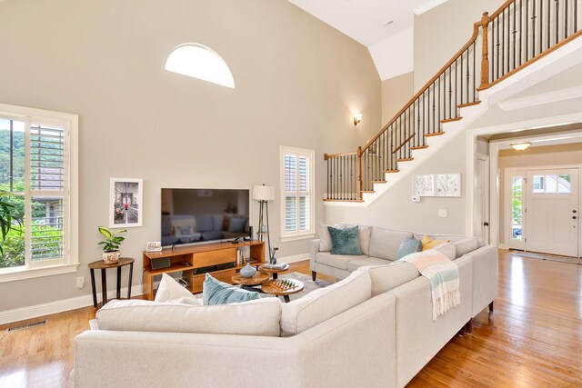 3429 Willow Lake Cir, Chattanooga, TN 37419 - living area featuring healthy amount of natural light, light wood-style flooring, high vaulted ceiling, baseboards, and stairs