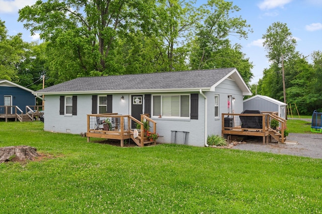 142 Jones Dr, Dunlap, TN 37327 - ranch-style home with a wooden deck, brick siding, a trampoline, and roof with shingles