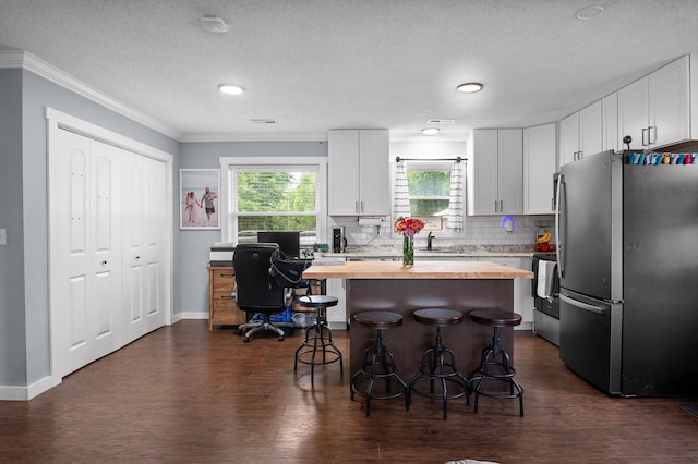 142 Jones Dr, Dunlap, TN 37327 - kitchen with wooden counters, freestanding refrigerator, a breakfast bar, ornamental molding, and white cabinetry
