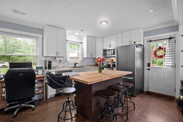 142 Jones Dr, Dunlap, TN 37327 - kitchen with stainless steel appliances, butcher block countertops, a textured ceiling, a sink, and a breakfast bar area
