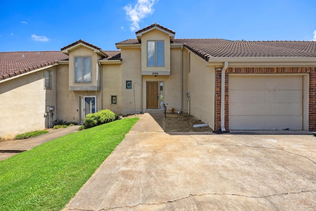 2138 Vaden Village Dr, Chattanooga, TN 37421 - view of front facade featuring stucco siding, an attached garage, a tiled roof, driveway, and a front lawn