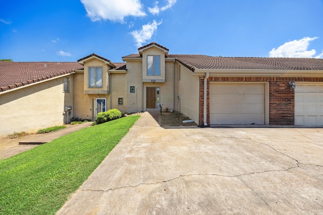 2138 Vaden Village Dr, Chattanooga, TN 37421 - view of front of house featuring driveway, stucco siding, a tiled roof, a garage, and a front yard