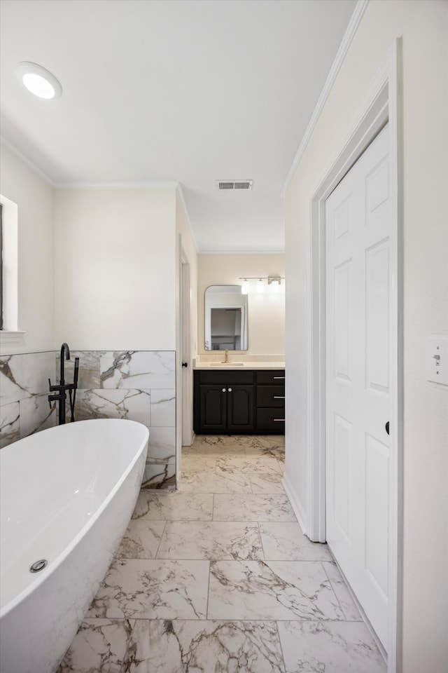 2138 Vaden Village Dr, Chattanooga, TN 37421 - bathroom featuring ornamental molding, a freestanding bath, vanity, marble finish floors, and a wainscoted wall