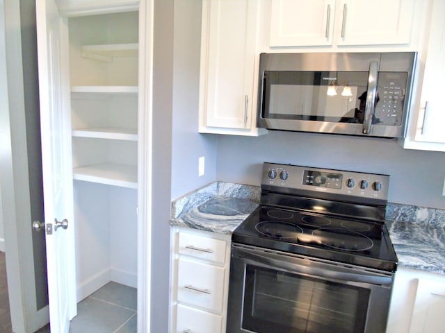 135 Joseph Daniel Ln, Jasper, TN 37347 - kitchen featuring appliances with stainless steel finishes, white cabinets, light stone counters, and tile patterned floors