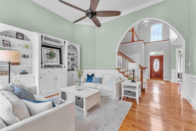 4155 Freewill Rd NW, Cleveland, TN 37312 - living room featuring arched walkways, crown molding, a wainscoted wall, stairway, and ceiling fan