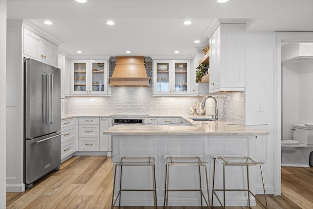 1131 Stringers Ridge Rd Unit 12E, Chattanooga, TN 37405 - kitchen featuring high quality fridge, custom exhaust hood, a sink, a peninsula, and light wood-style floors