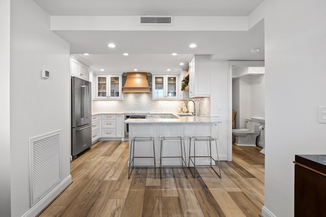 1131 Stringers Ridge Rd Unit 12E, Chattanooga, TN 37405 - kitchen featuring high end refrigerator, custom exhaust hood, a peninsula, oven, and light wood-type flooring