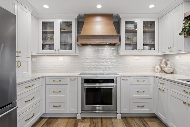1131 Stringers Ridge Rd Unit 12E, Chattanooga, TN 37405 - kitchen featuring appliances with stainless steel finishes, custom range hood, white cabinetry, decorative backsplash, and recessed lighting