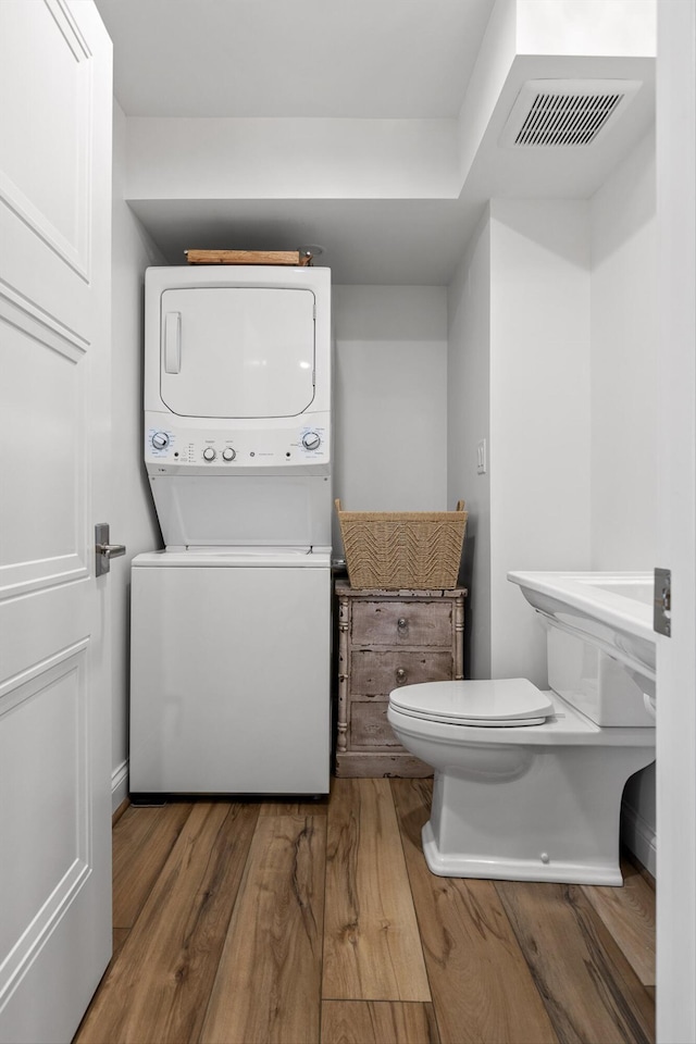 1131 Stringers Ridge Rd Unit 12E, Chattanooga, TN 37405 - bathroom with stacked washer / dryer, wood finished floors, and toilet
