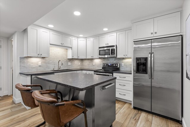 1131 Stringers Ridge Rd Unit 12B, Chattanooga, TN 37405 - kitchen featuring appliances with stainless steel finishes, a sink, dark countertops, a kitchen bar, and recessed lighting