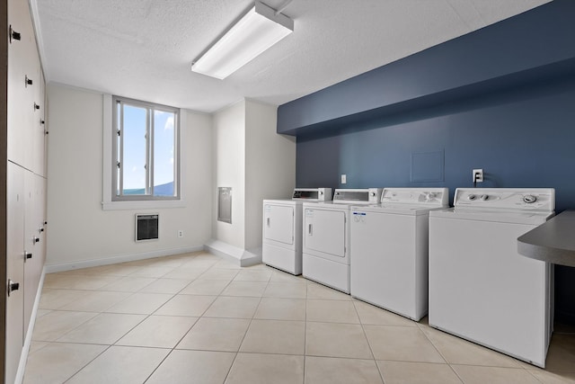 1131 Stringers Ridge Rd Unit 12B, Chattanooga, TN 37405 - communal laundry room with heating unit, washing machine and dryer, a textured ceiling, baseboards, and light tile patterned floors